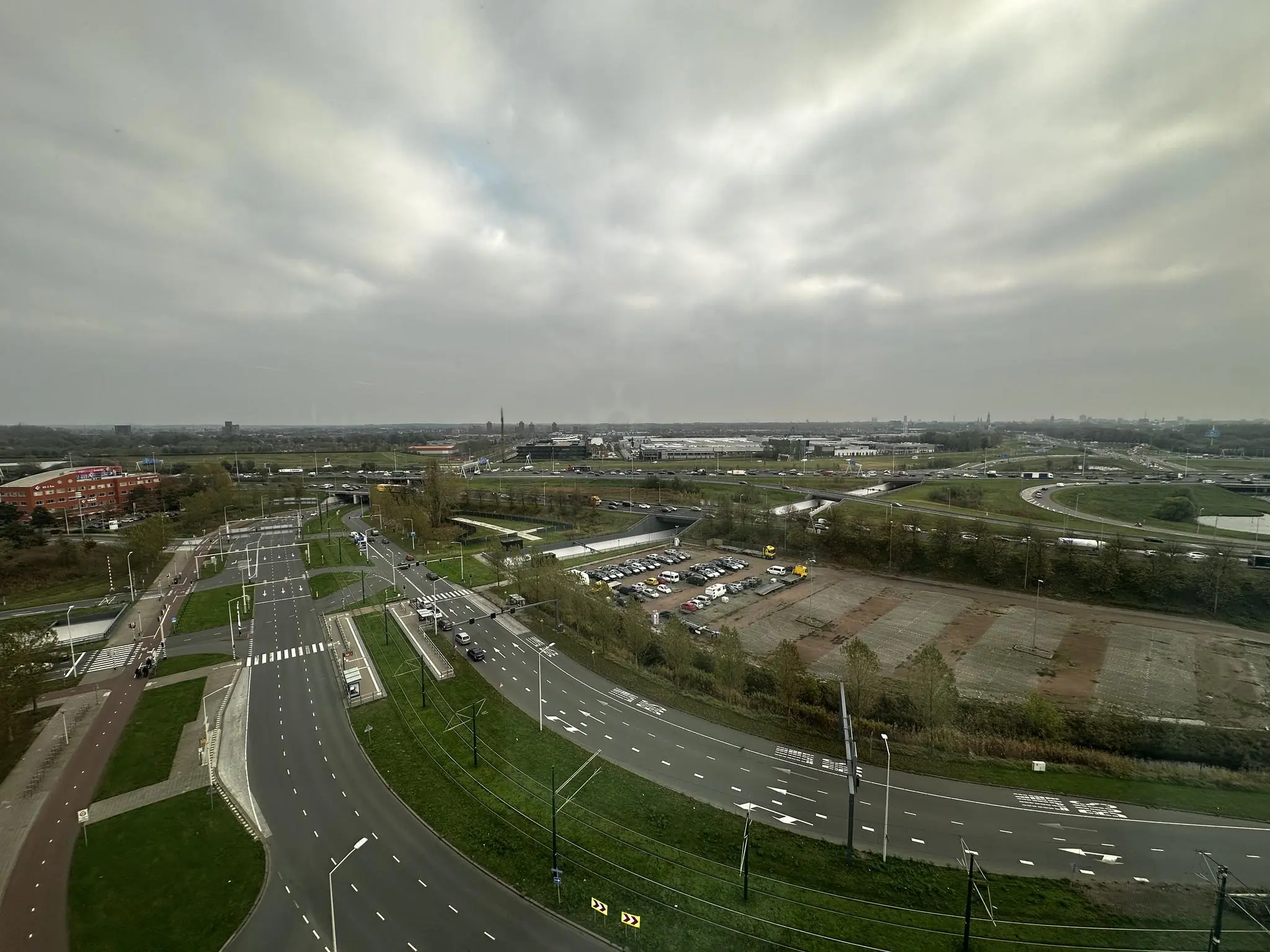 Overzichtsfoto van de Laan van Zuid Hoorn in Den Haag, met meerdere wegen, een parkeergelegenheid en omliggende bebouwing onder een bewolkte lucht.